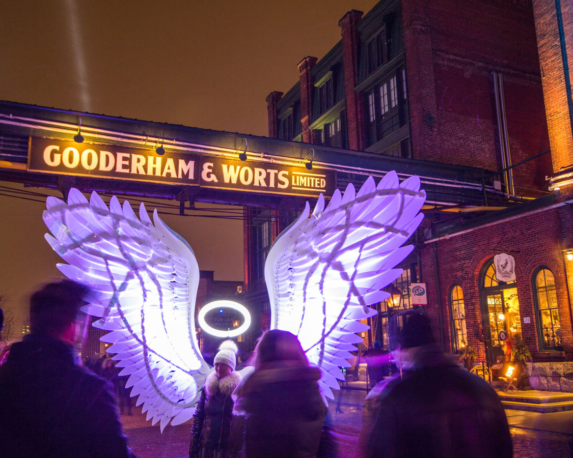 Angel wings and the Gooderham and Worts sign in the Distillery District during the Toronto LightFest