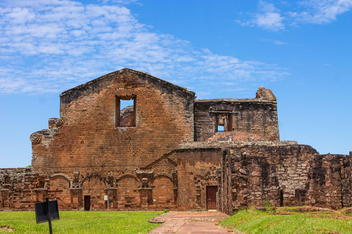 Broken stone and roof peaks marked by large window in the ruins of Trinidad in Paraguay