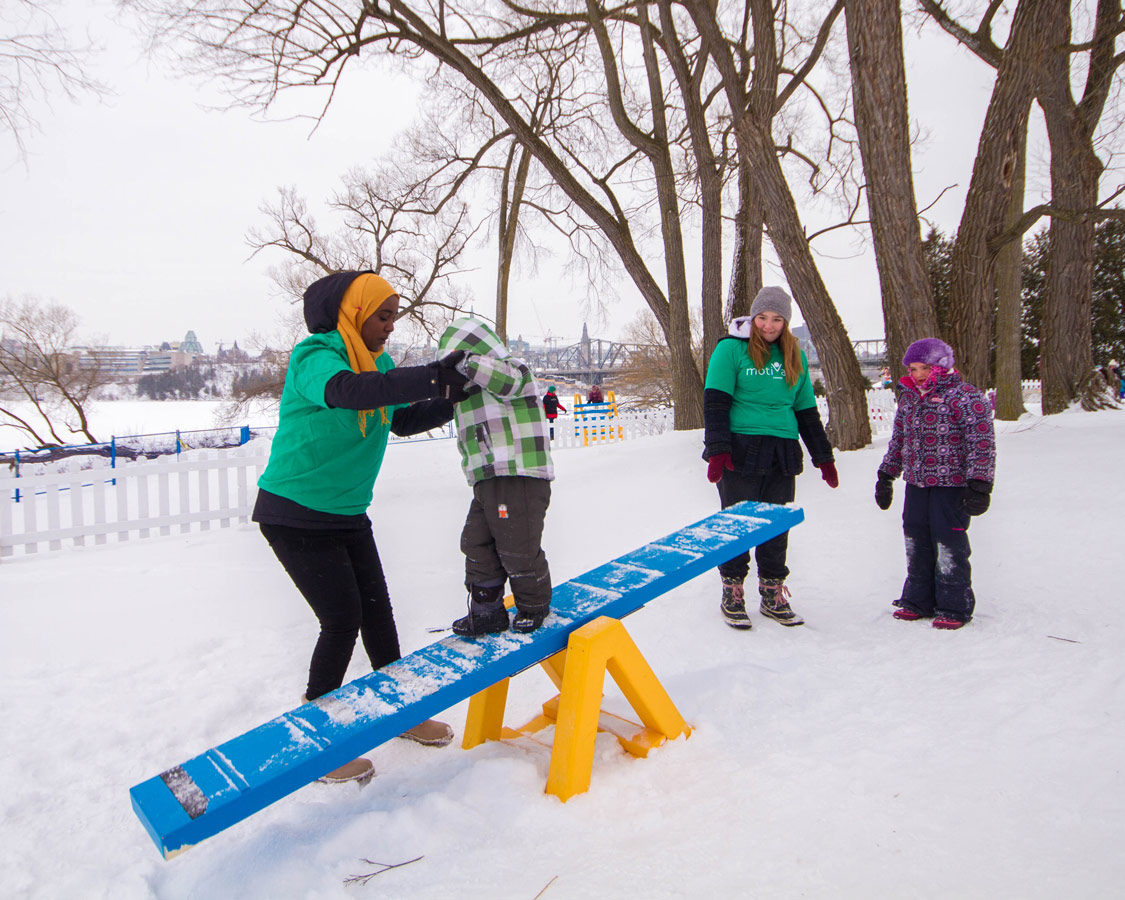 Boy crossing a seesaw as part of an obstacle course at Winterlude.