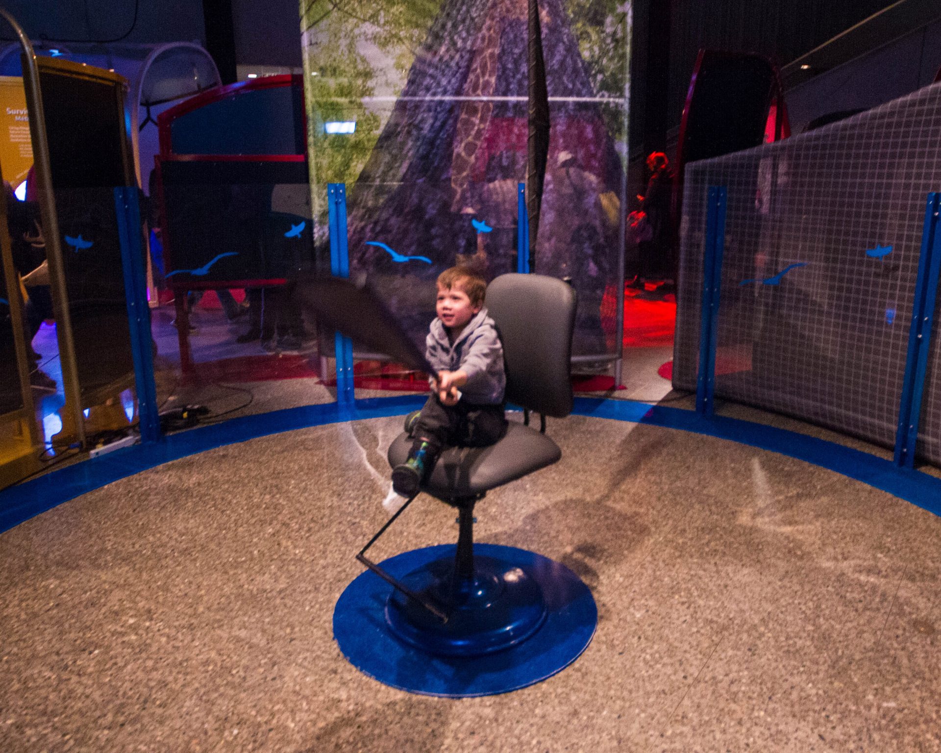 Small boy flaps a makeshift wing at the Ontario Science Centre Bio Mechanics Exhibit