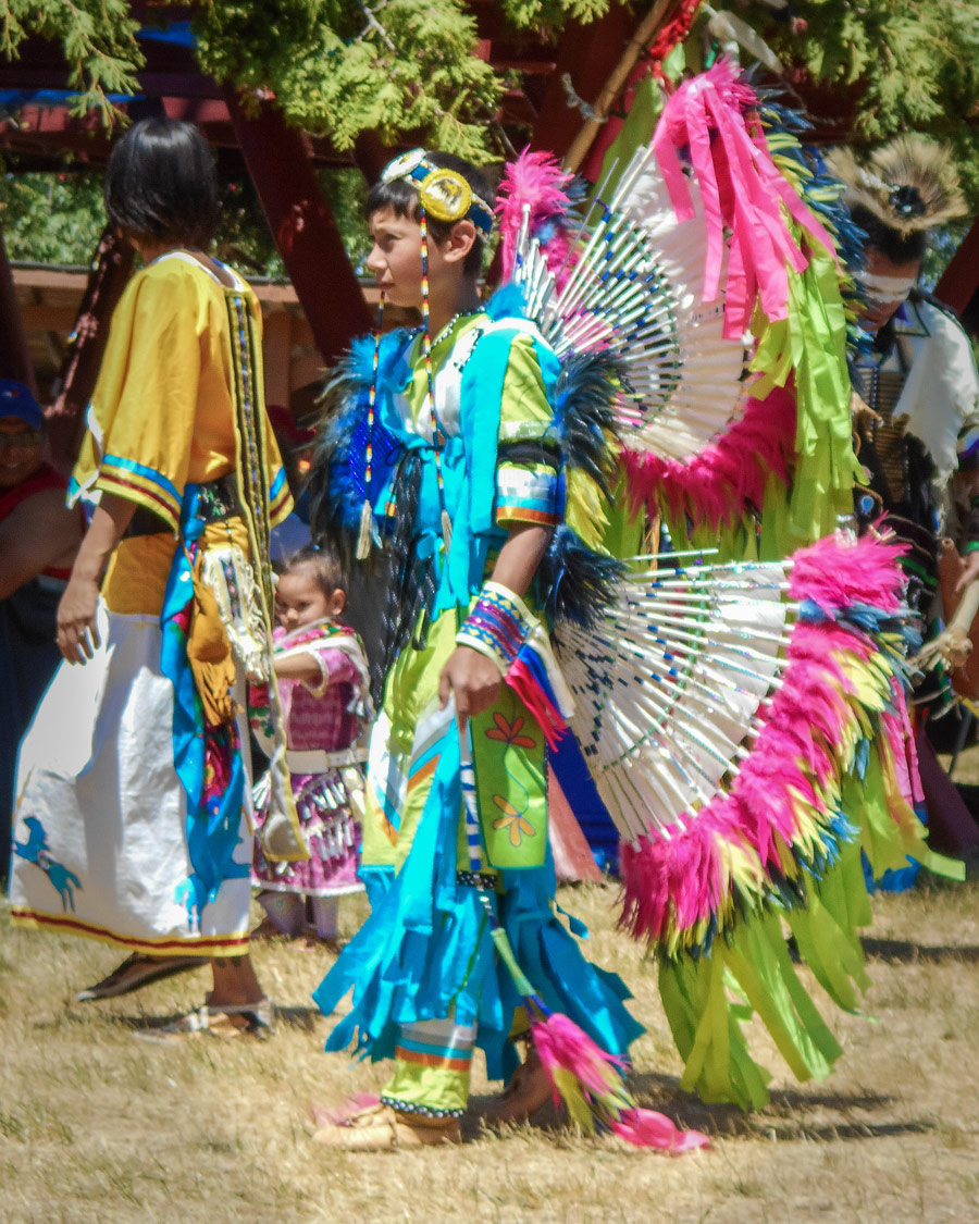 An adolescent dancer in colorful regalia at a First Nations Pow Wow