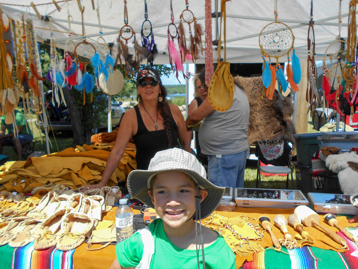 A young boy smiles next to experience a first nations pow wow in Ontario