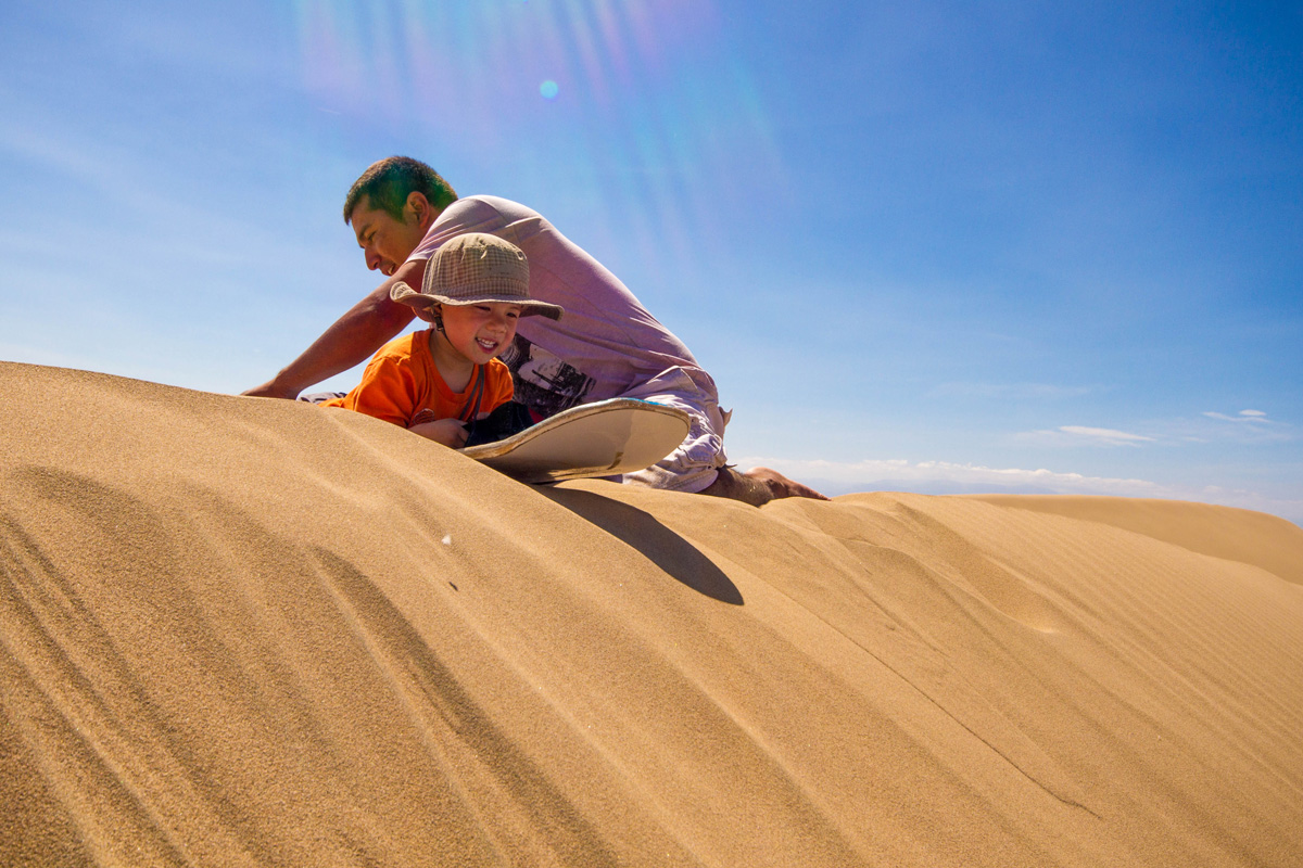 A toddler prepares to go sandboarding in Peru with Kids near Huacachina