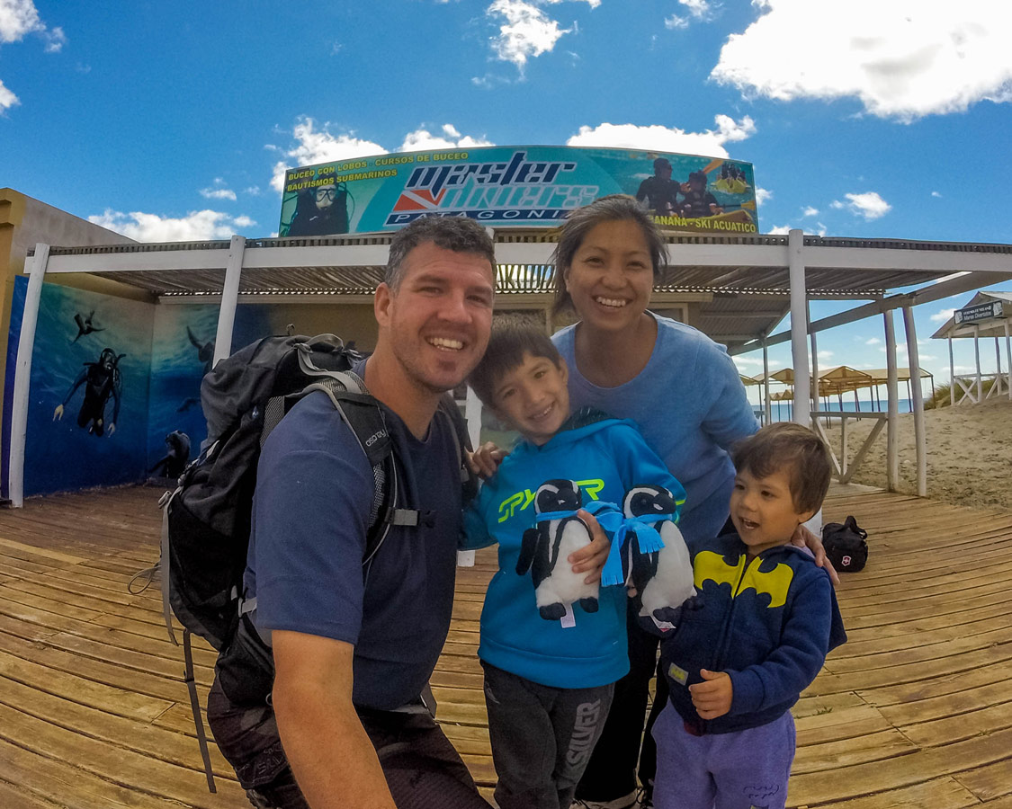 A mixed race family takes a selfie outside of a dive shop in Puerto Madryn Argentina