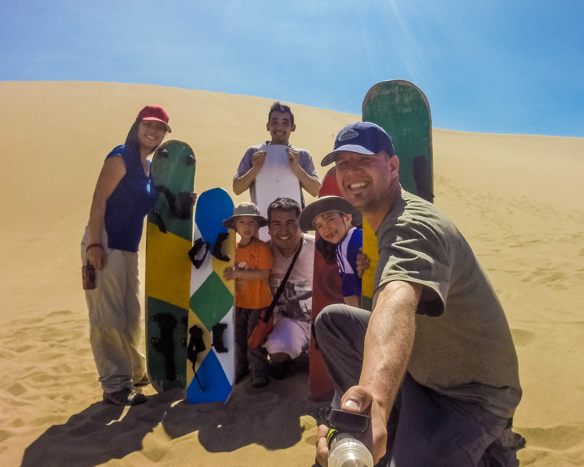 a group shot of sandboarders in Huacachina, Peru