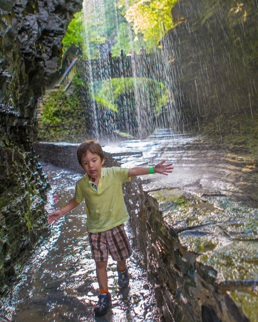Boy playing under a waterfall at Wakings Glen State Park.