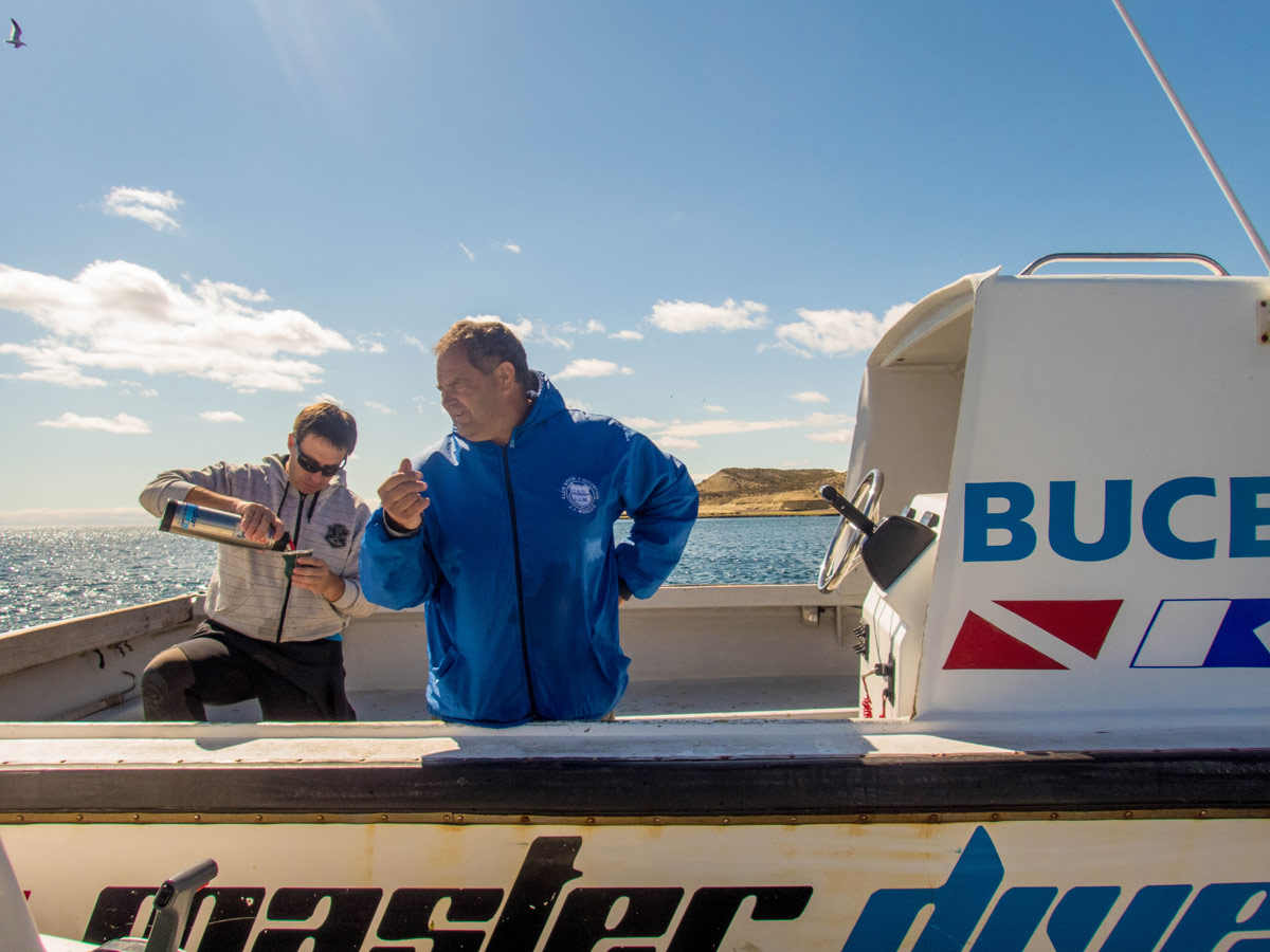 Two SCUBA diving guides drink Mate tea on a dive boat