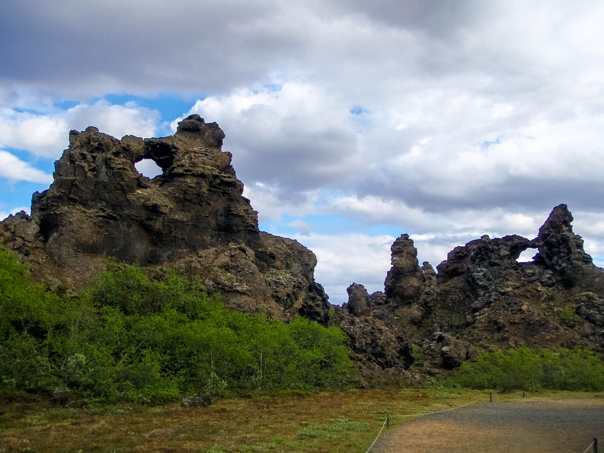 The mysterious arched lava rocks stand out from the green bushes in Dimmuborgir near Lake Myvatn Iceland