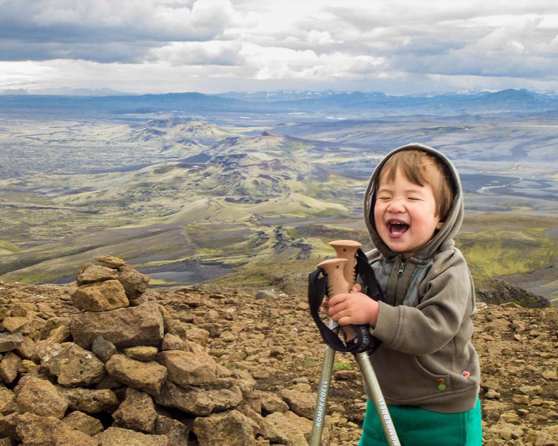 Young boy laughing during trek Iceland at Lakagigar Crater Row
