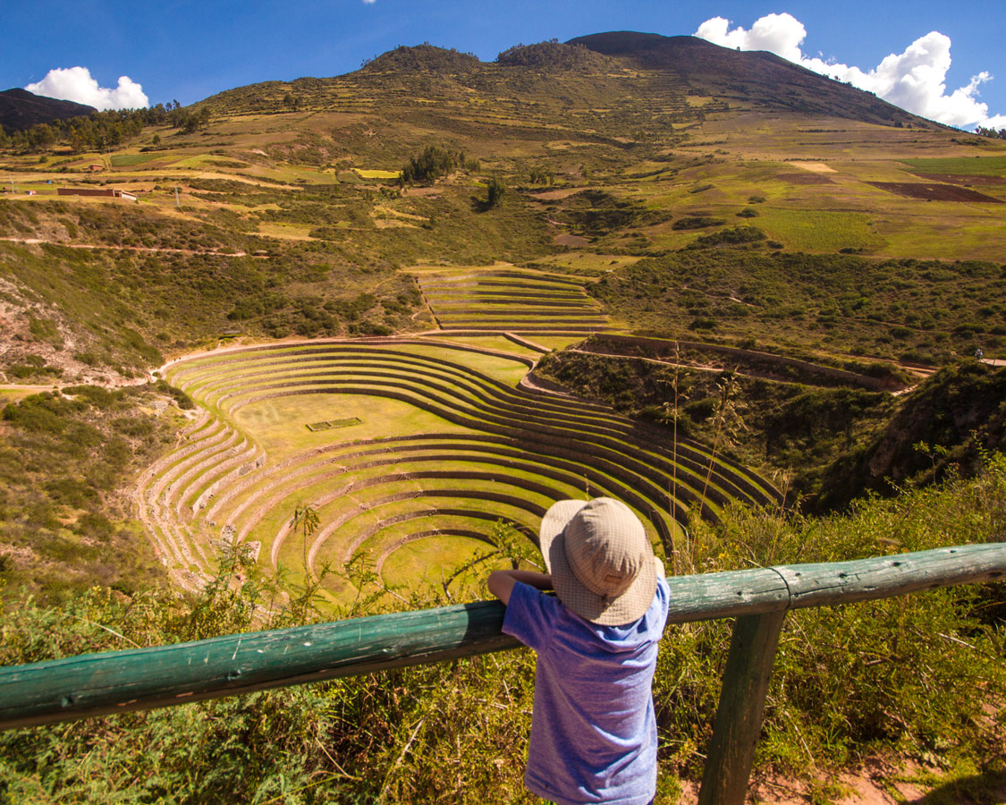 Boy looking out onto the Moray ruins in the Sacred Valley, Peru.