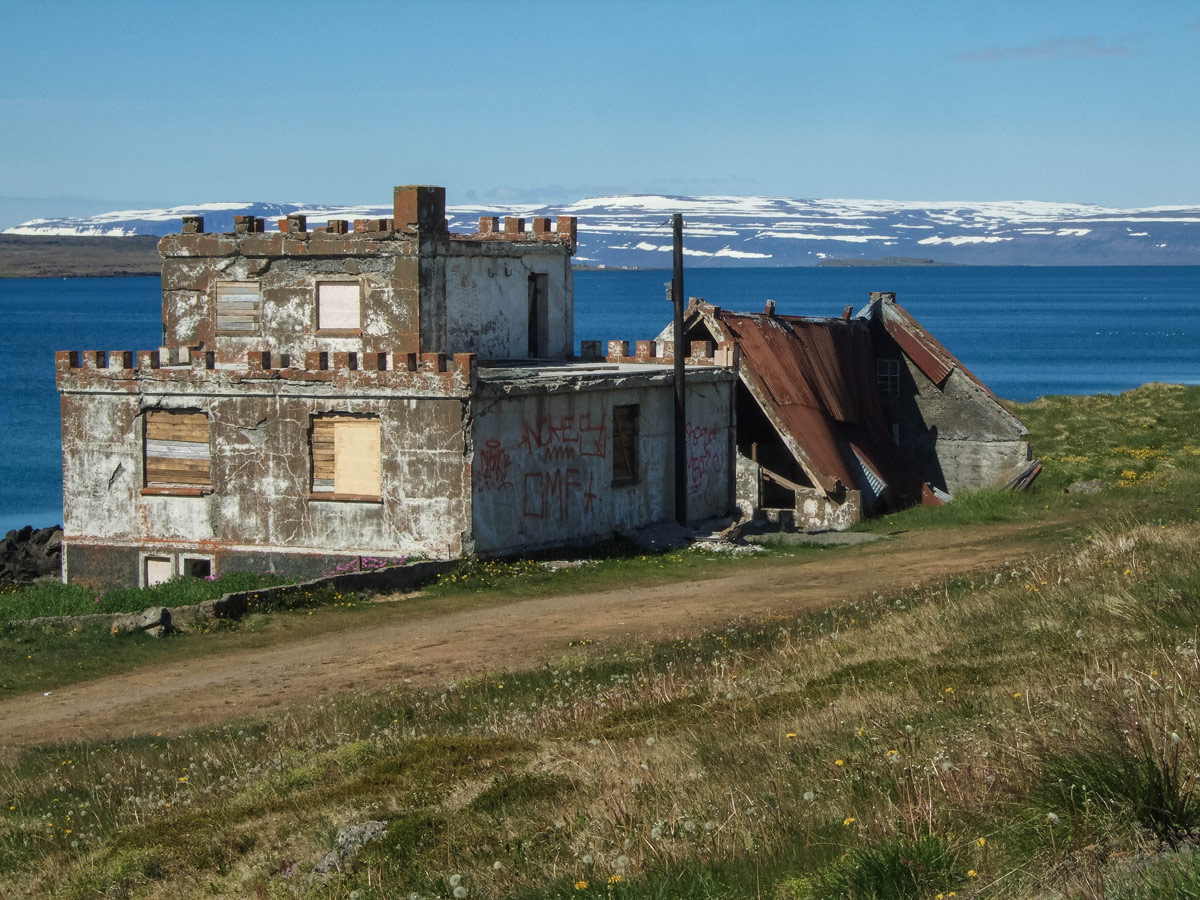 A dilapidated castle-style home on the edge of a fjord in Iceland