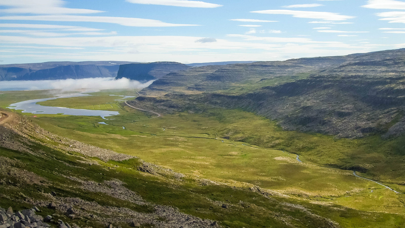 A valley lit by the sun among mountains in Iceland's Westfjords