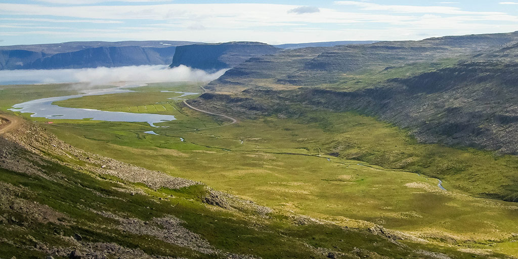A valley lit by the sun among mountains in Iceland's Westfjords