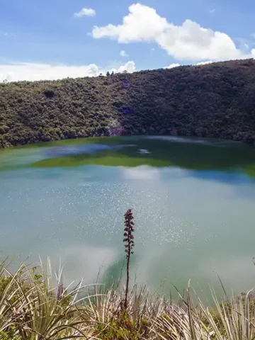 Lake Guatavita sparkles under a blue sky