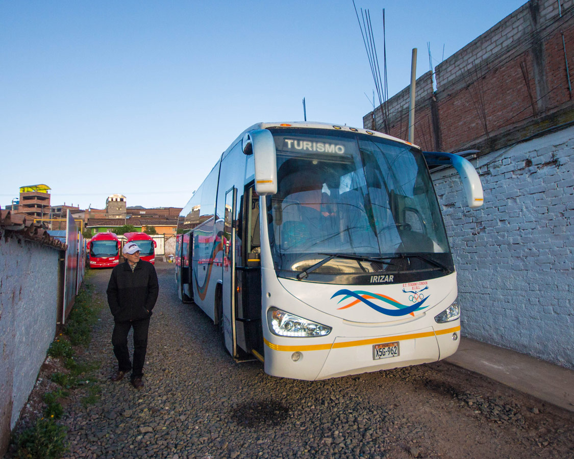 An Inca Express Cusco to Puno bus picks up passengers in an alley in Cusco Peru