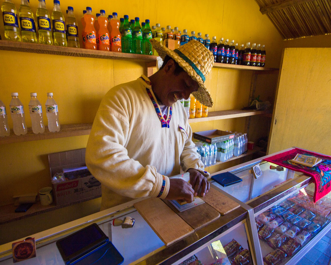 A Uru elder stamps a passport at the store on Isla de los Uros on Lake Titicaca