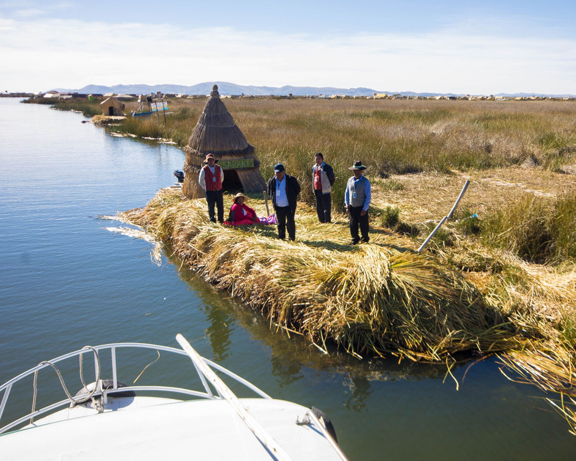 Uros people collect tickets from tour boats on Lake Titicaca Peru