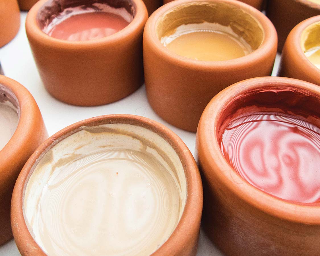 Ceramic jars full of paint at the Pablo Seminario ceramic workshop Taller Ceramico with kids