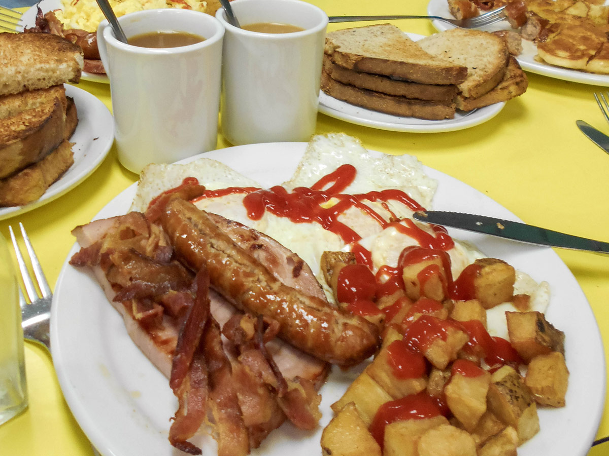 Breakfast at Mums Bakery in Mindemoya Manitoulin Island. A plate of eggs, sausages, bacon and toast with some coffee is one of the best things to do on Manitoulin Island