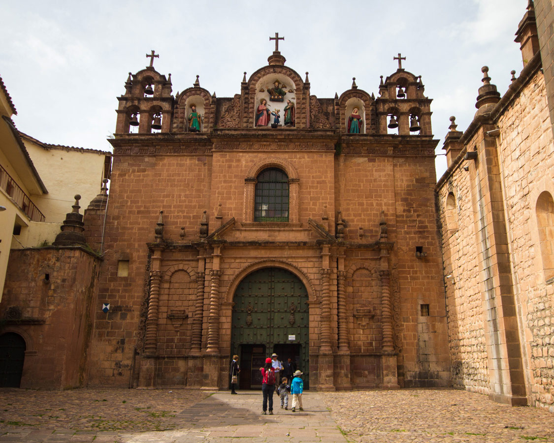 Tourists enter the huge doors of the catholic cathedral in the Plaza d'Armas . It is one of the top things to do in Cusco Peru