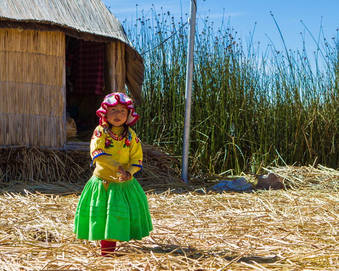 A young Uros girl on Isla de los Uros on Lake Titicaca near Puno Peru with kids on a 14 day Peru itinerary