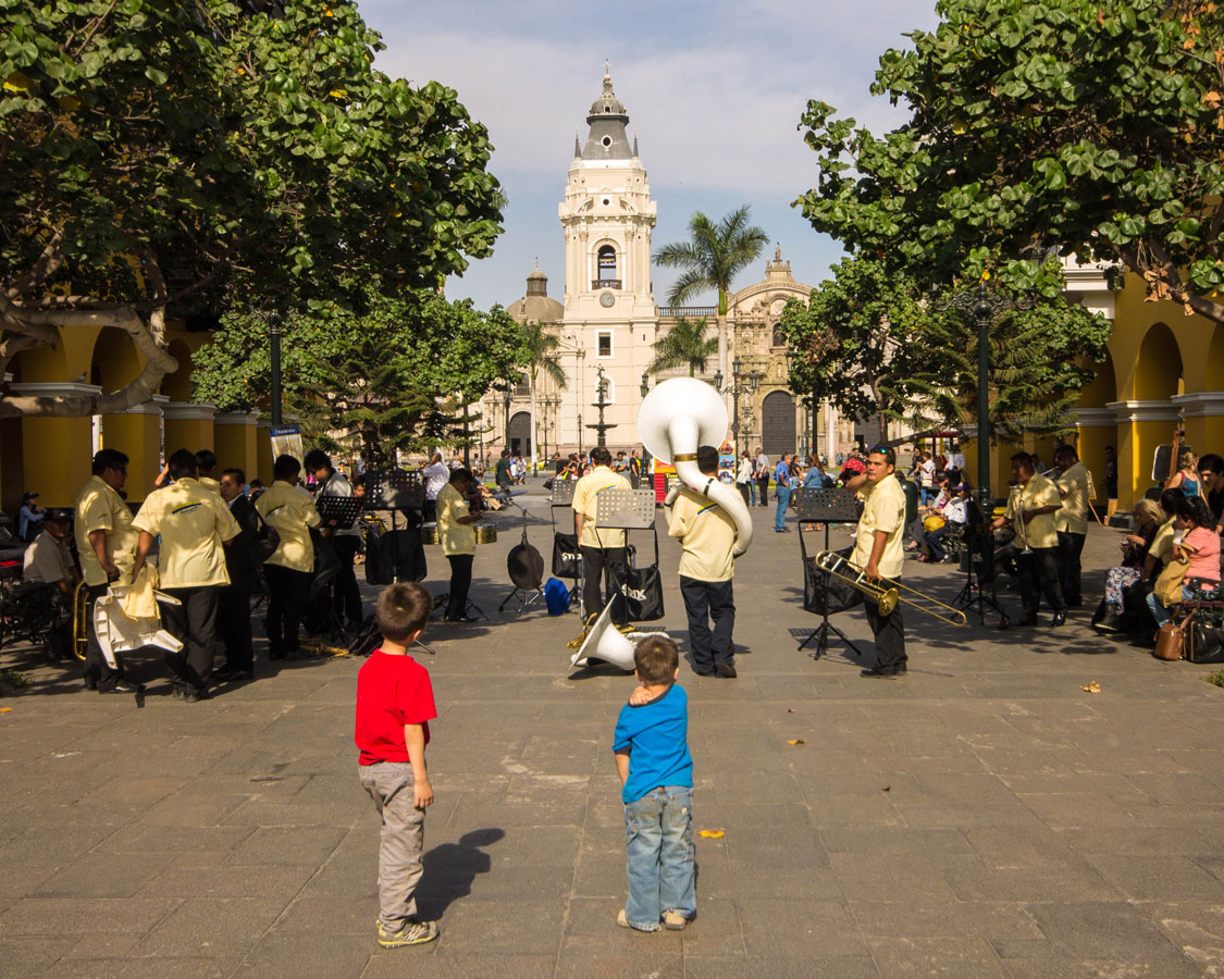 Boys watching a band play on the streets of Lima Peru with kids during 2 weeks in Peru