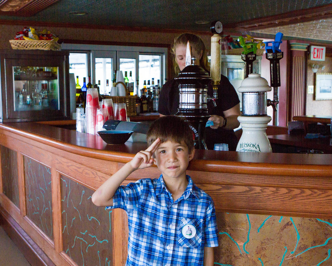A boy gives a salute at the bar on the Muskoka Lake Steamship Wenonah II in Gravenhurst Ontario