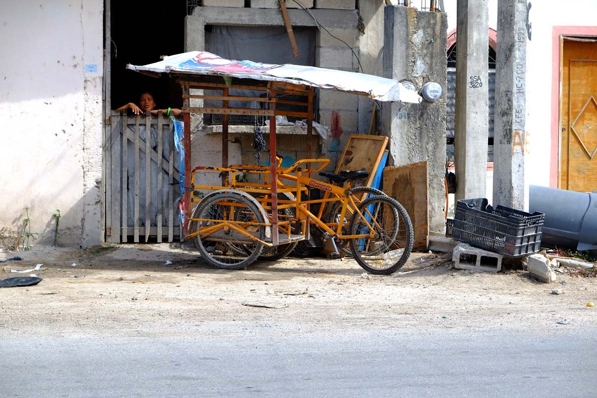 A Mexican villager looks out a window near a bike rack in Tulum Mexico