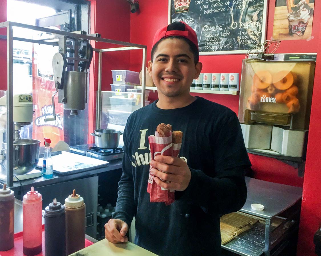 Serving churros at Pancho's Bakery in Kensington Market Toronto Food tour with Tasty Tours Toronto