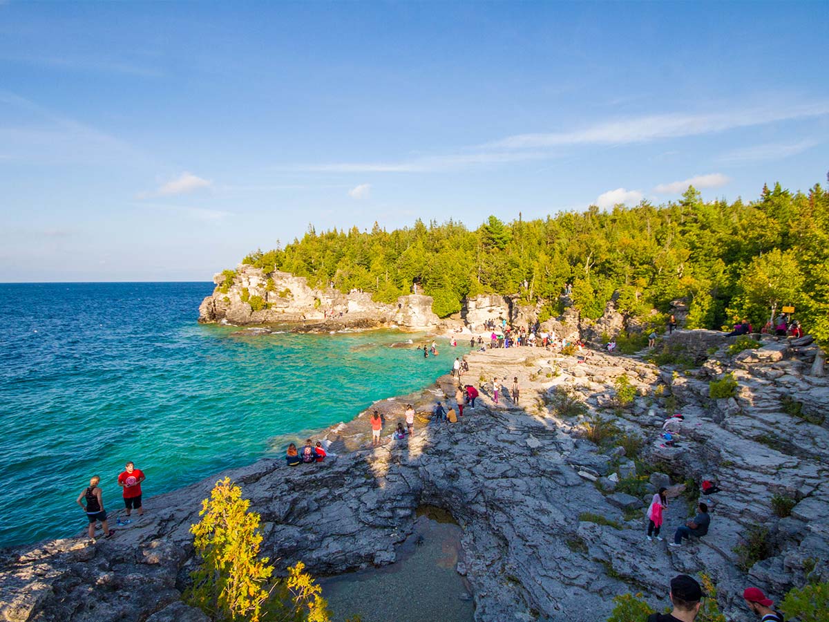Visitors to Bruce Peninsula National Park lounge on the rocks near the Grotto