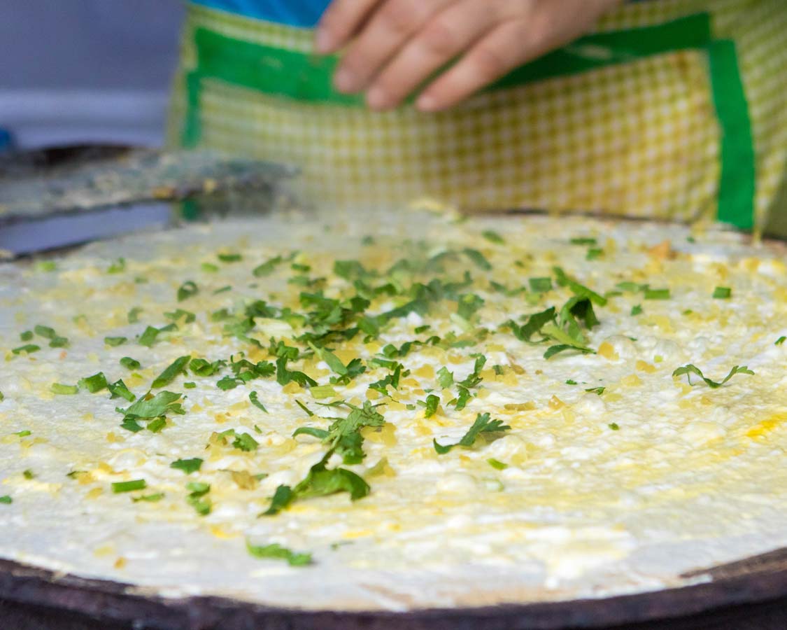 A street vendor in Shanghai China makes Jiangbing over a hot plate on a Shanghai food tour