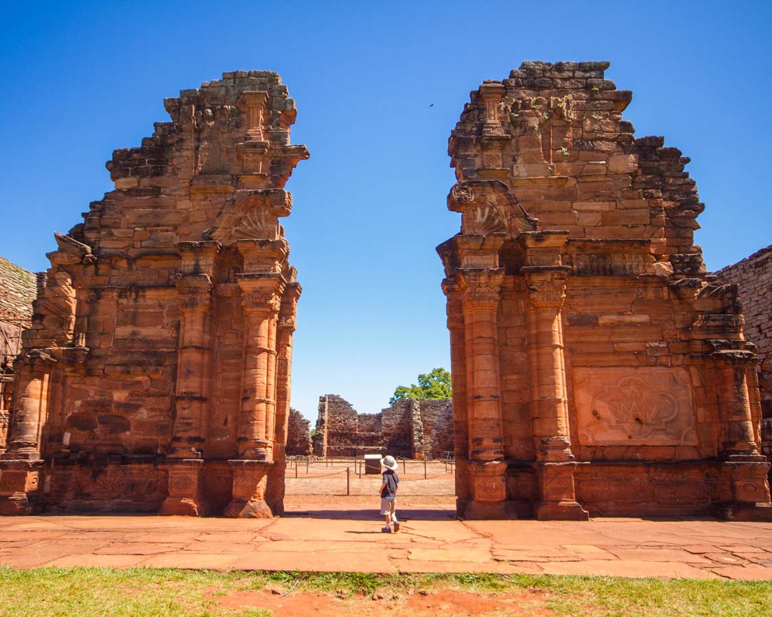 A young boy stares up at the The towering walls of the church of the Jesuit Ruins of San Ignacio Miní in San Ignacio, Argentina