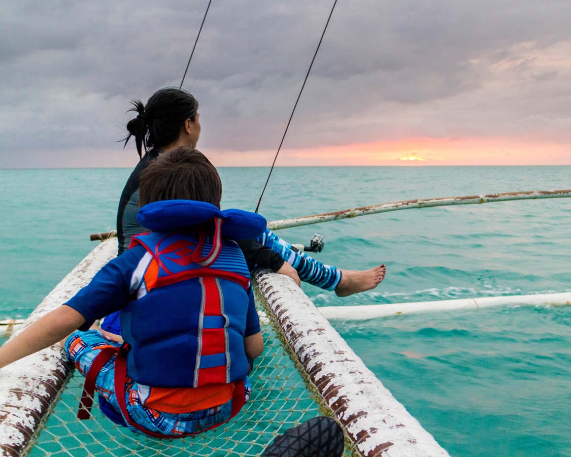 Mother and son enjoying a Paraw Sailing sunset cruise in Boracay Philippines