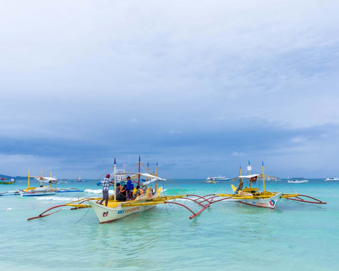 Paraw boats docked in the blue water at Station 2 in Boracay Philippines