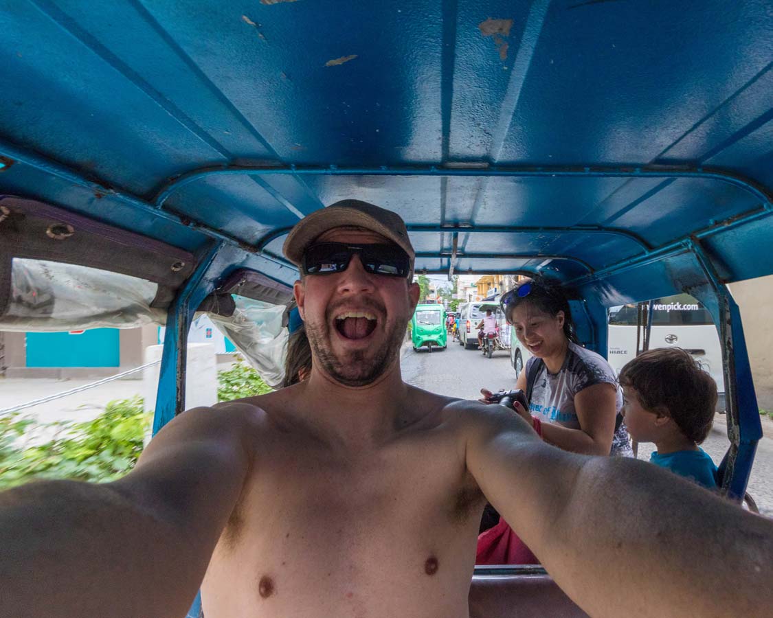 A man and his family ride a tuk tuk tricycle in Boracay Philippines