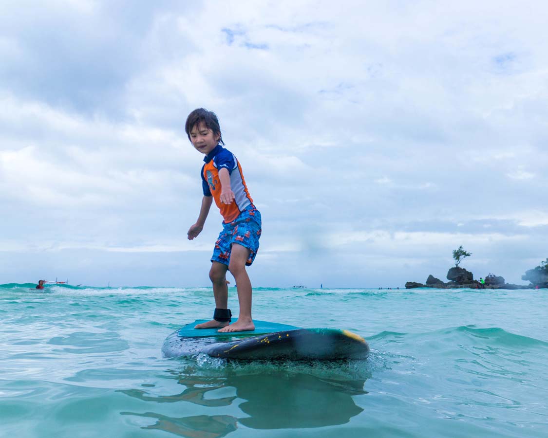 Young boy surfing in Boracay Philippines