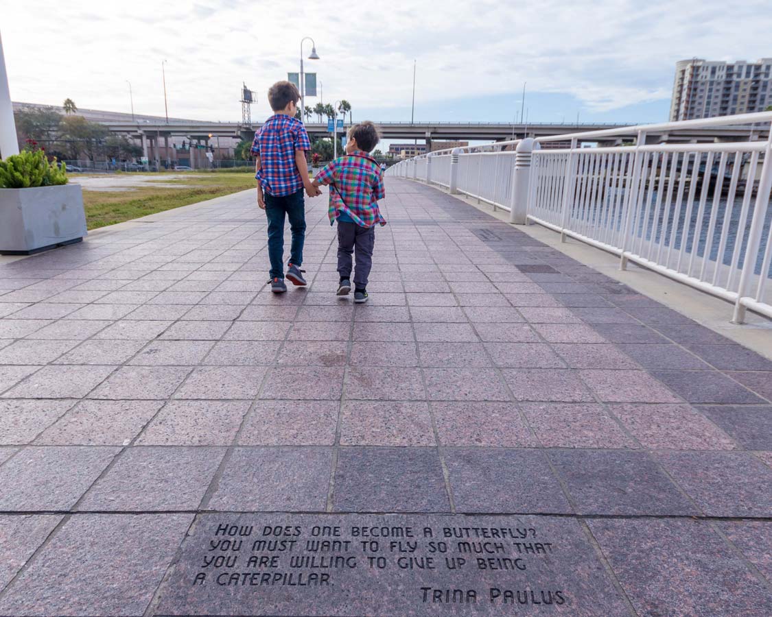 Two boys walk along the Tampa Riverwalk in Florida