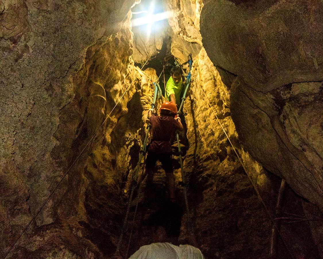 Adventure travel child Climbing ropes at Ugong Rock in Puerto Princesa Philippines