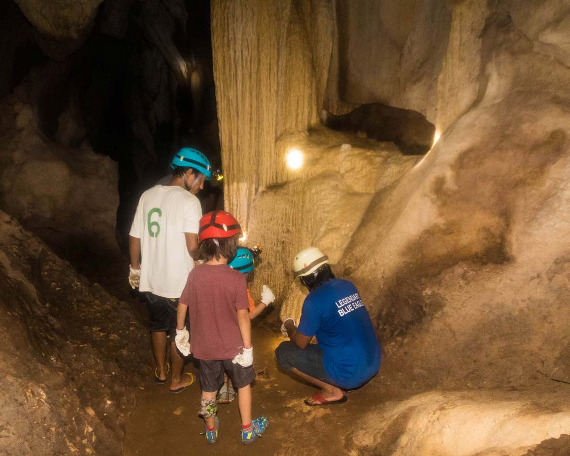 cave guides show two boys cave features at Hundred Caves Puerto Princesa Philippines