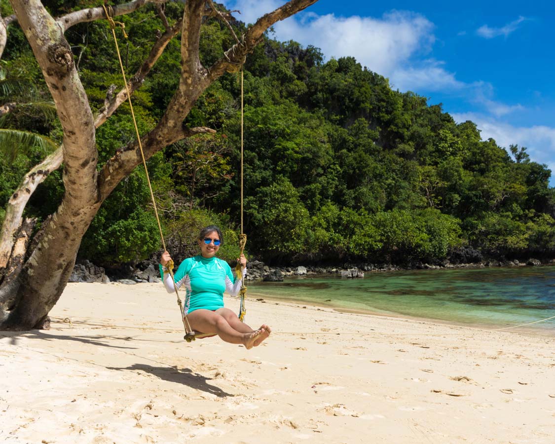 Woman on a swing at 7 Commando Beach in El Nido Philippines