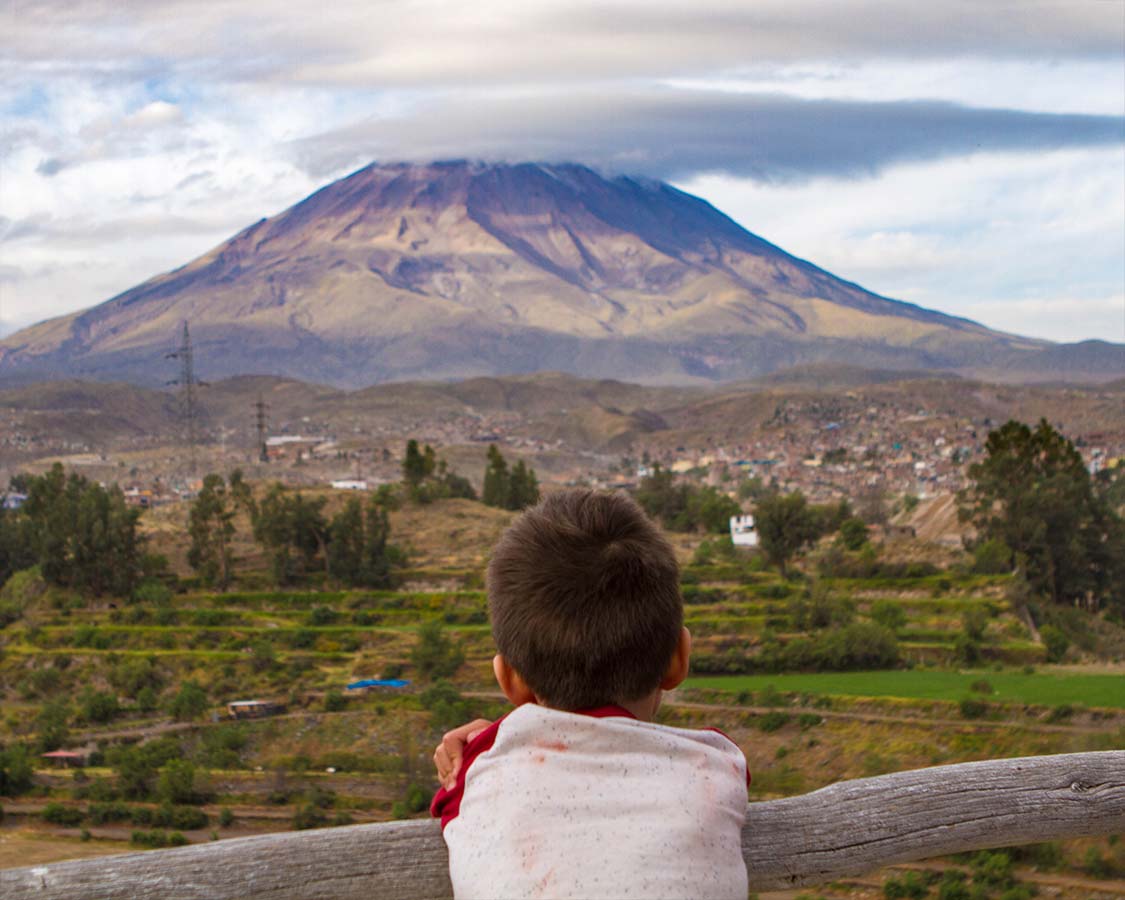 Boy looking at a volcano in Arequipa Peru