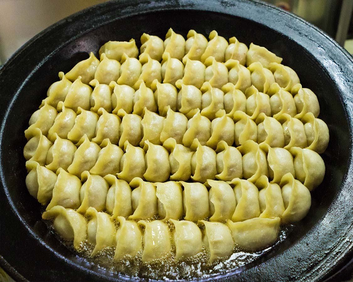 Chinese soup dumplings being fried in Shanghai food tour