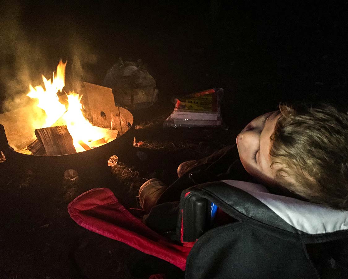 boy sleeping by a campfire in Lake Superior Provincial Park