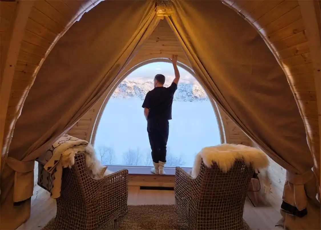 Man standing at a window at the Kirkenes Snowresort