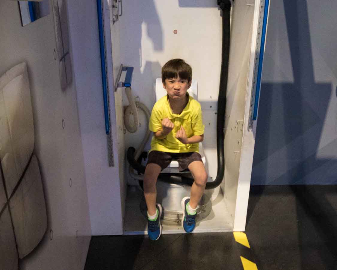 Testing astronaut toilet at Kennedy Space Center for families