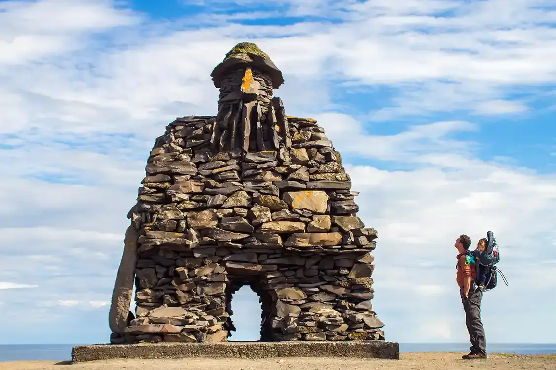 A father packs for Iceland with a child carrier and warm clothes