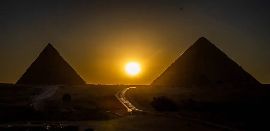 Sun setting between the pyramids of Giza