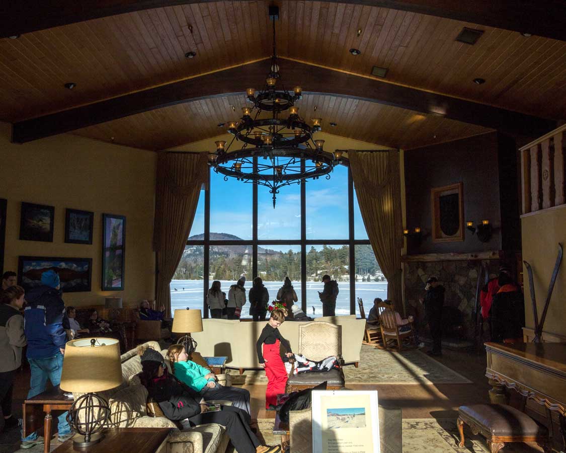 The luxurious interior of the Golden Arrow Hotel lobby looking out over Mirror Lake in Lake Placid