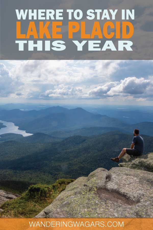 A man sitting on top of a mountain overlooking a shimmering lake