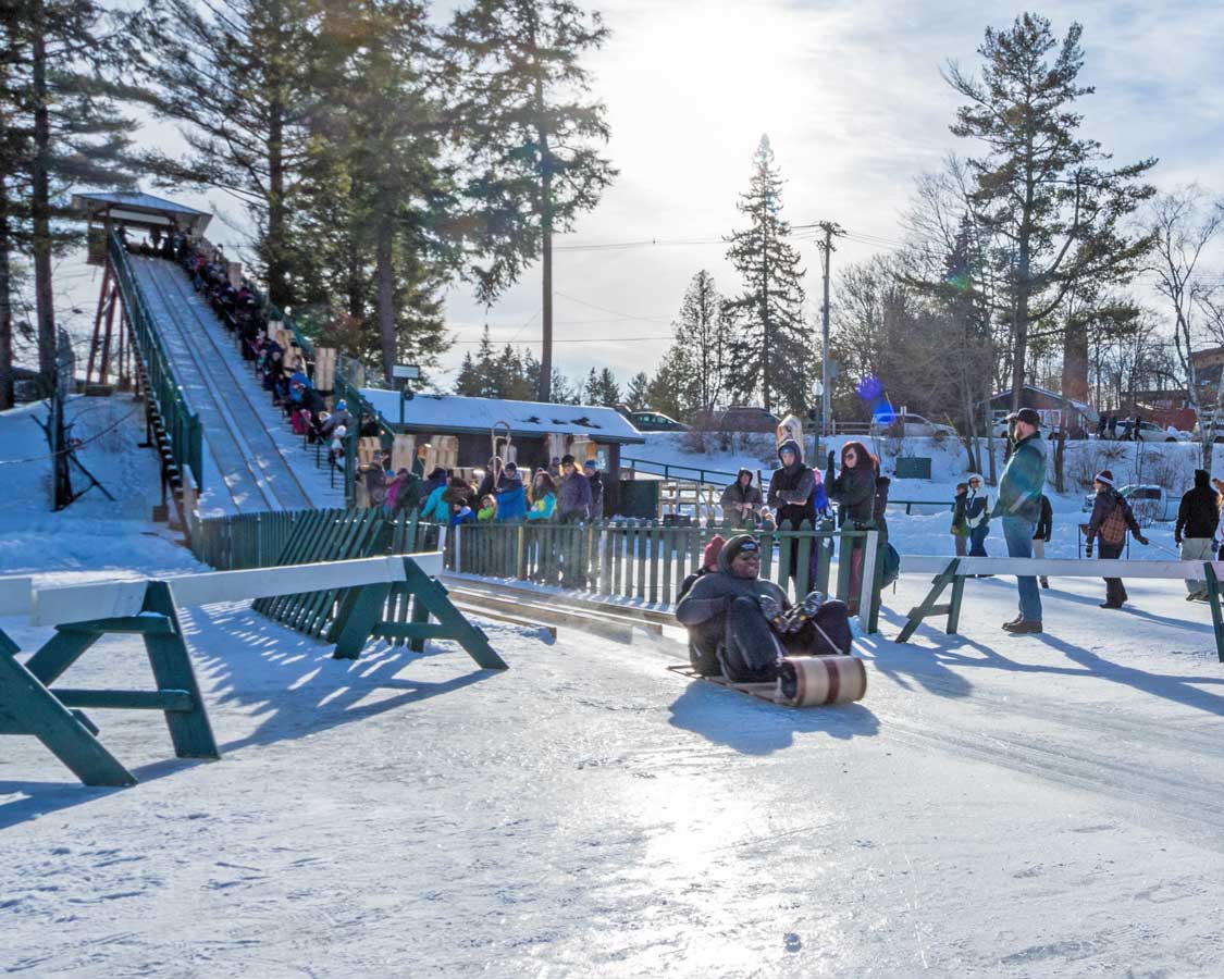 Crowds watch tobogganers slide across the lake in Lake Placid